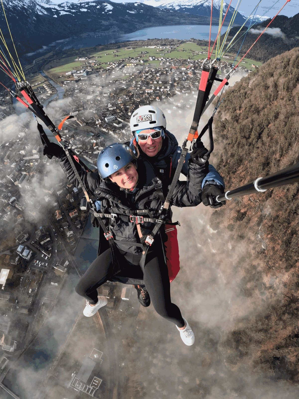 Avery Zenz tandem paragliding above a mountain town and lake